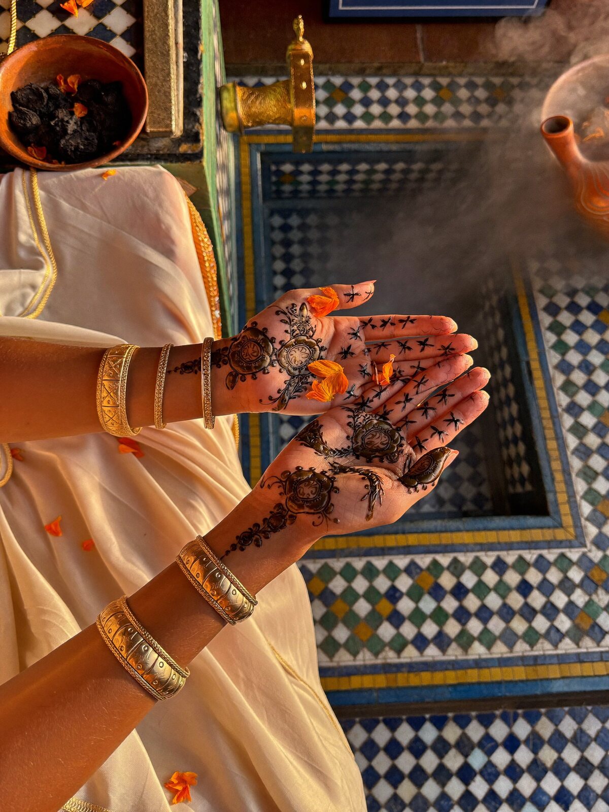 Bride's hands with fresh henna on saffron silk